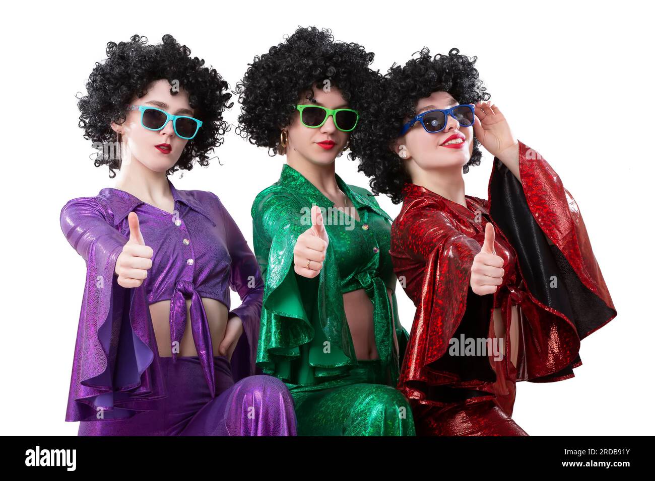 Disco style girls in colorful flared suits and African American wigs on a white background. Seventies or eighties style. Stock Photo