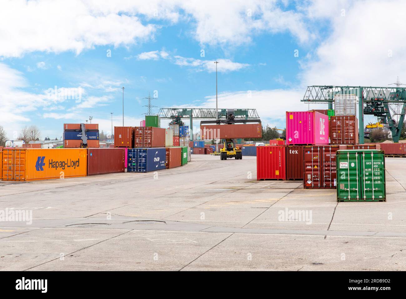 A top loader vehicle moves and stacks intermodal shipping containers at an Inland Container Depot (ICD) in England. Stock Photo