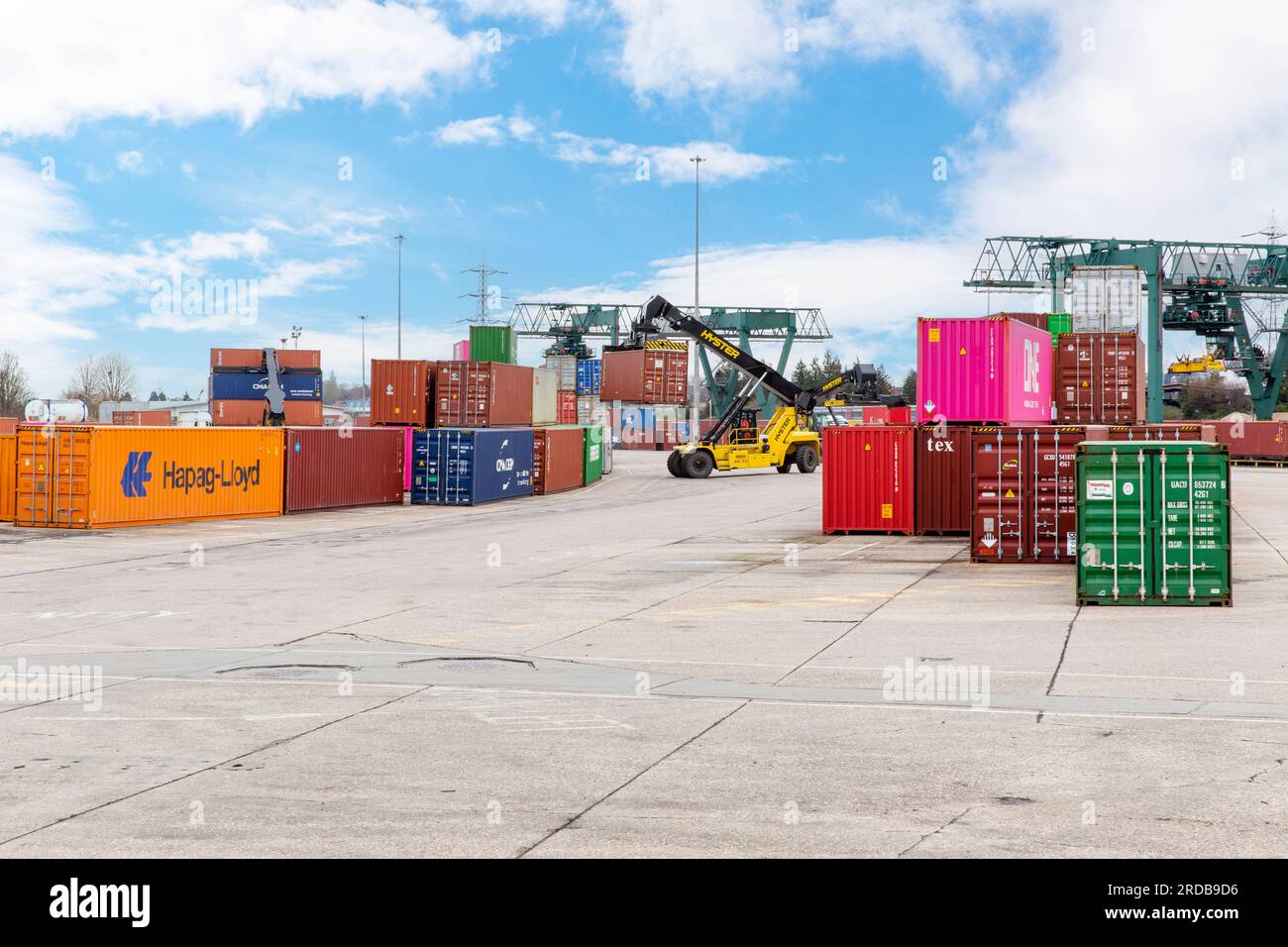 A top loader vehicle moves and stacks intermodal shipping containers at an Inland Container Depot (ICD) in England. Stock Photo