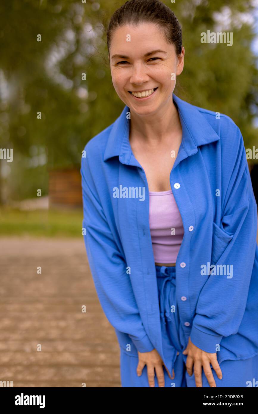 excited woman look up and down with open smile walking outdoors, speaking with pets or child Stock Photo