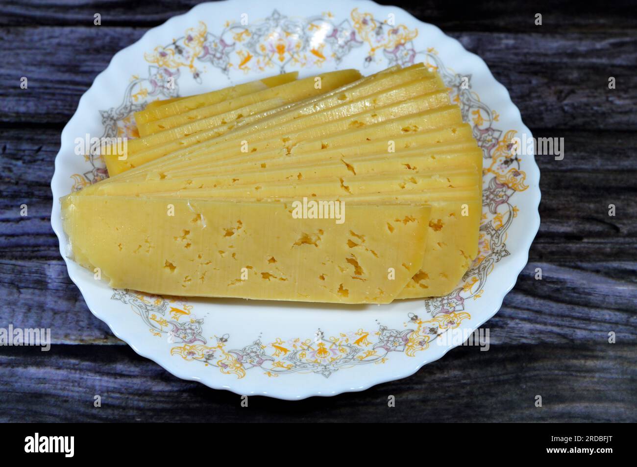 Slices of Egyptian Rumi cheese, also called gebna romiya or gebna turkiya, Roumi, Romi also Romy, middle Eastern parmesan hard cheese, has a pungent s Stock Photo