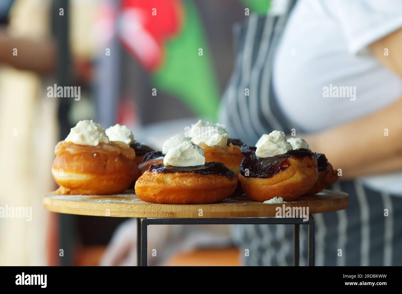Selling Bavarian doughnuts, deep fried doughnuts with fruit jam and farmers cream cheese displayed at the stall at farmers street food market in Pragu Stock Photo