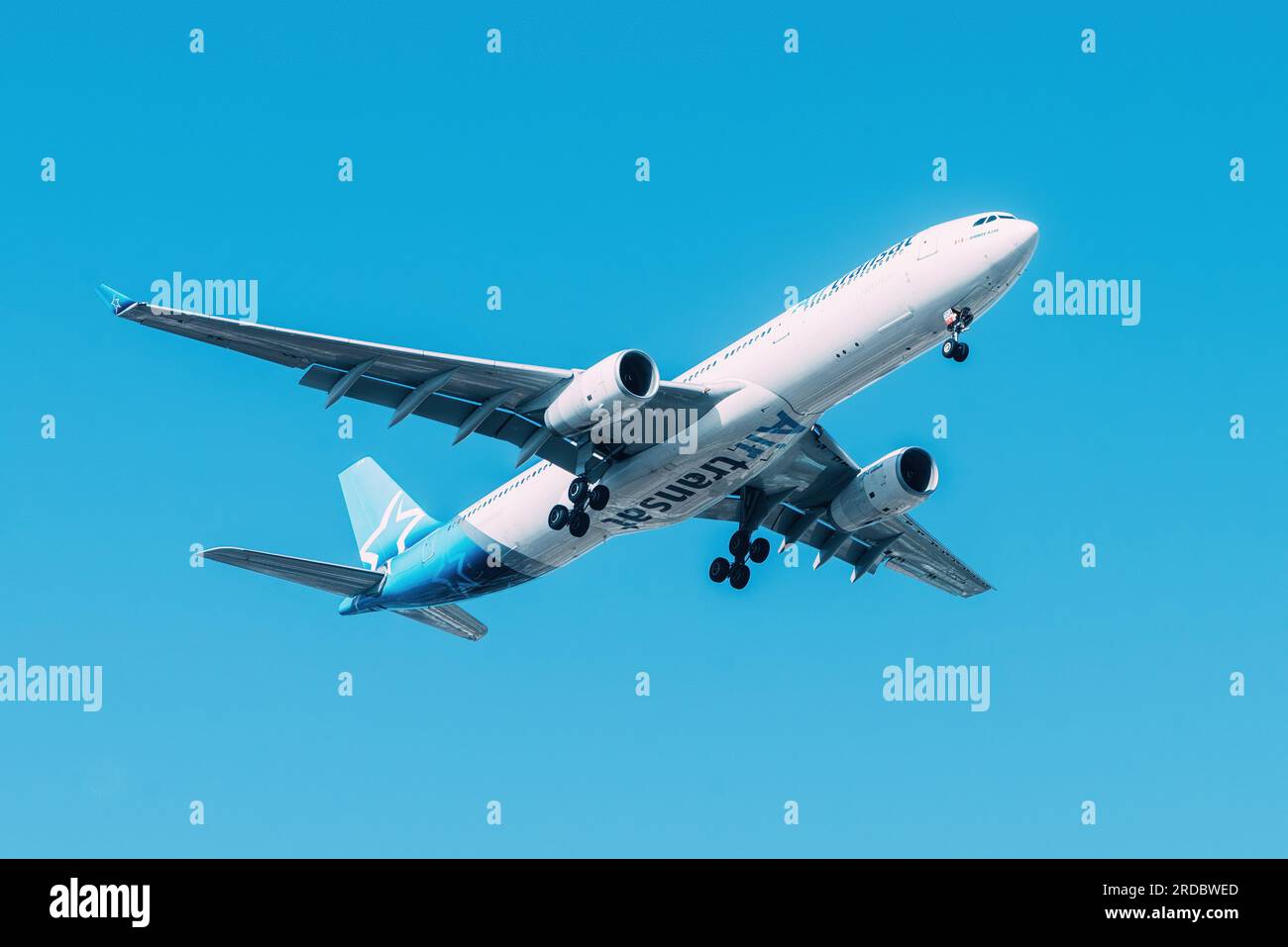 Lisbon, Portugal - July 18, 2023: Canadian air company Air Transat with Airbus A330 approaching to land at Lisbon International Airport against blue Stock Photo