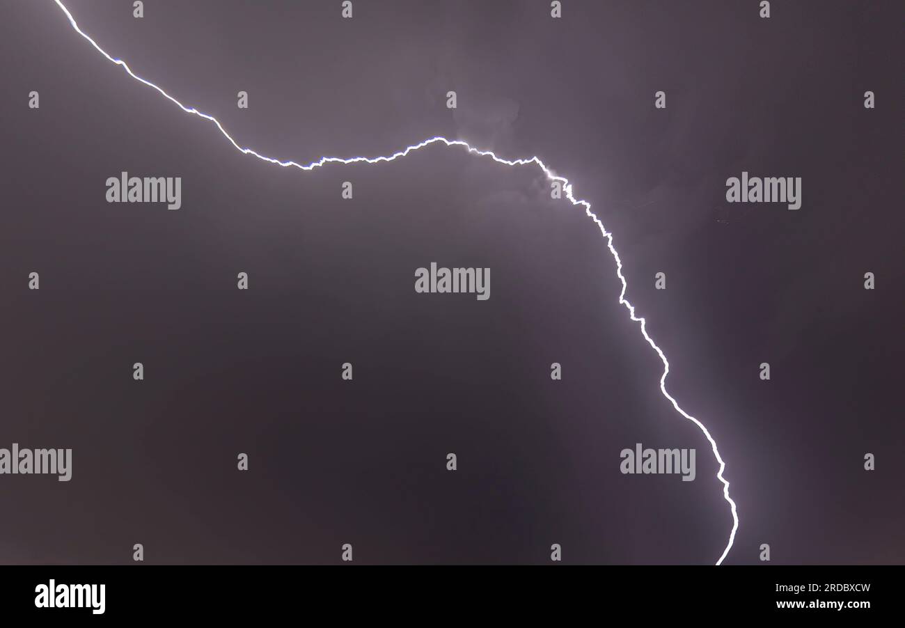 Picture of a flash in the night sky with glowing clouds in summer Stock