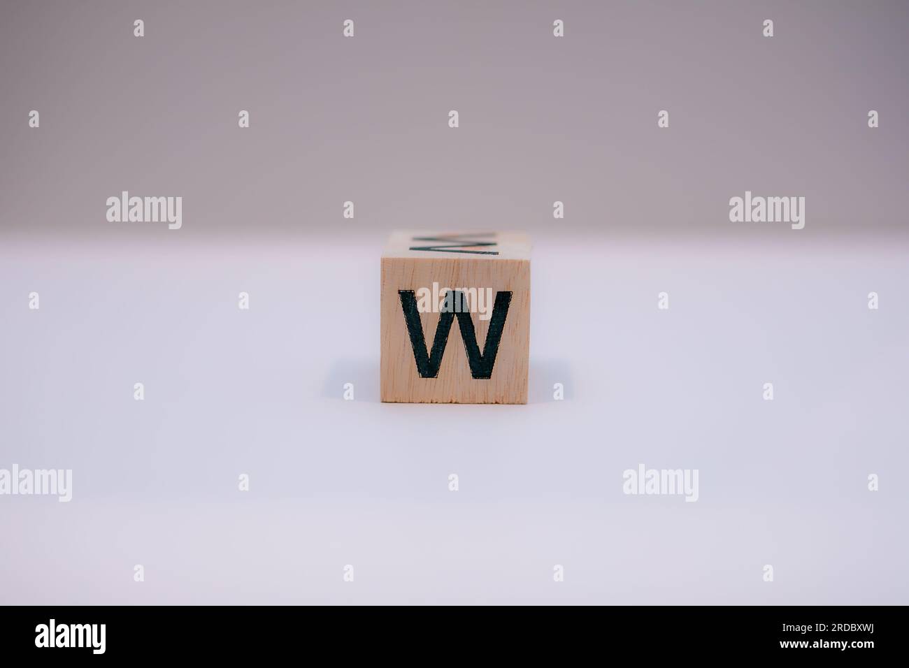 Wooden block written 'W' with a white background. Stock Photo