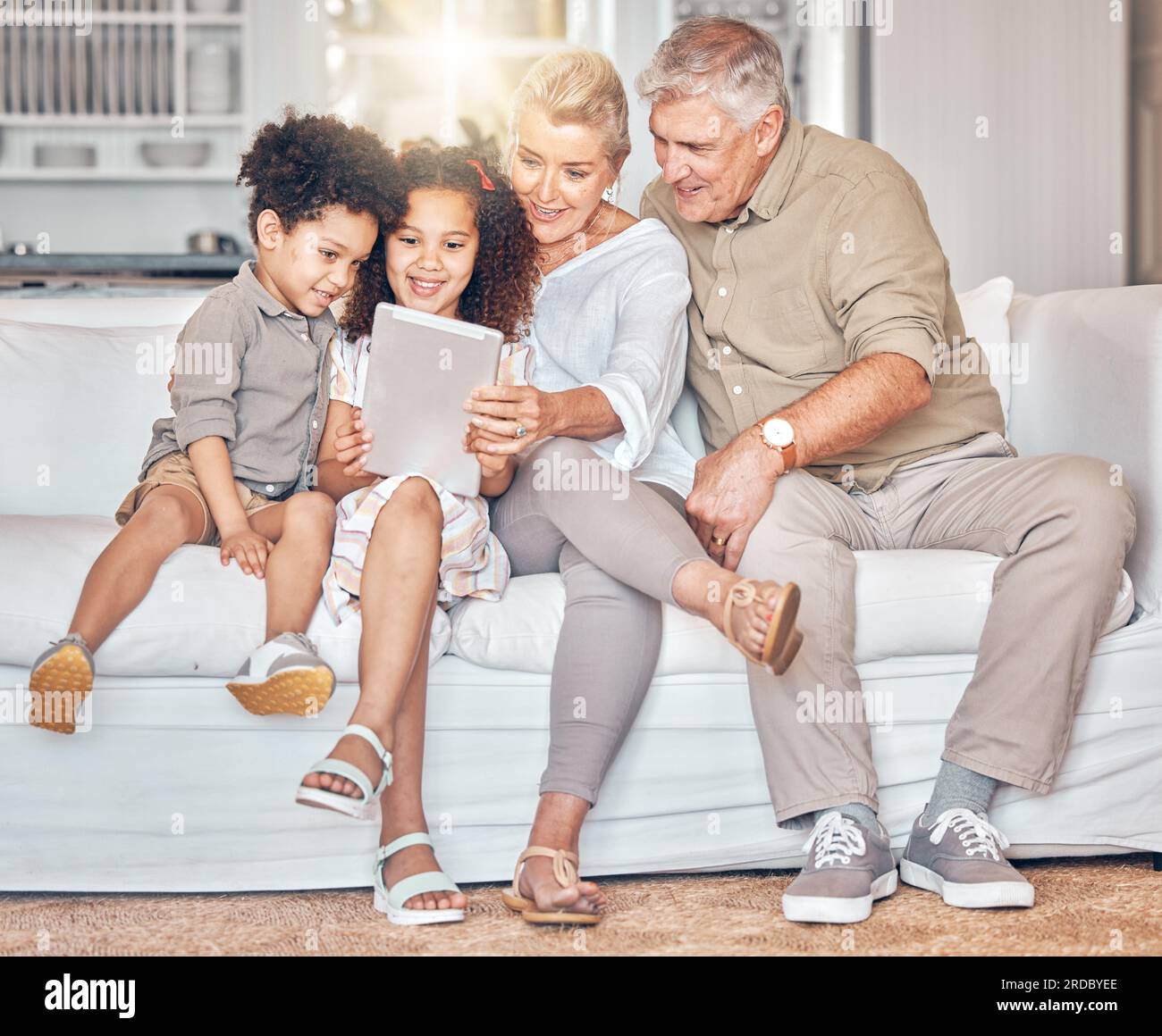 Social media children and grandparents with tablet in a house