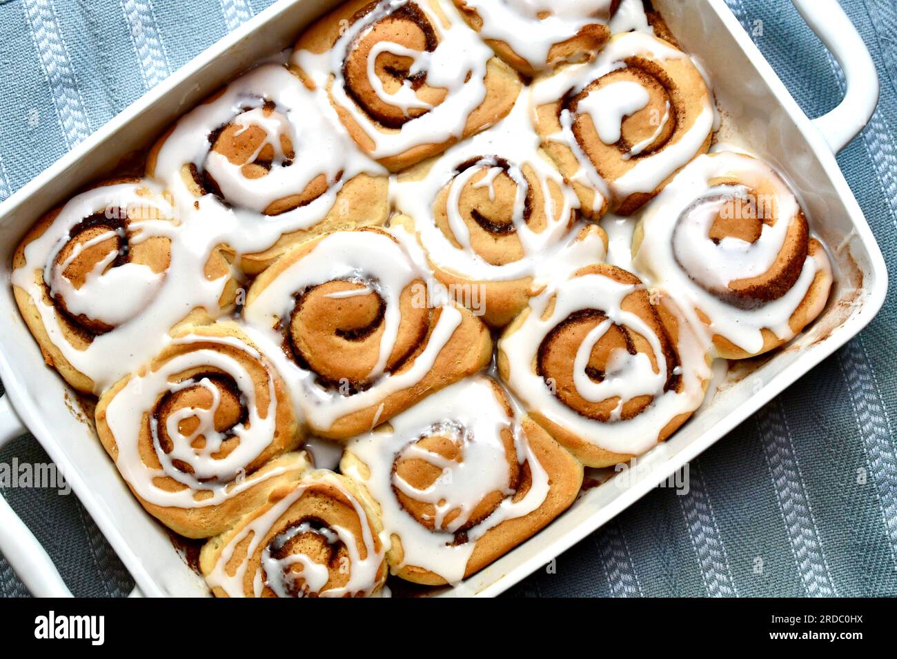 Cinnamon rolls in an oblong white baking dish viewed from above Stock Photo
