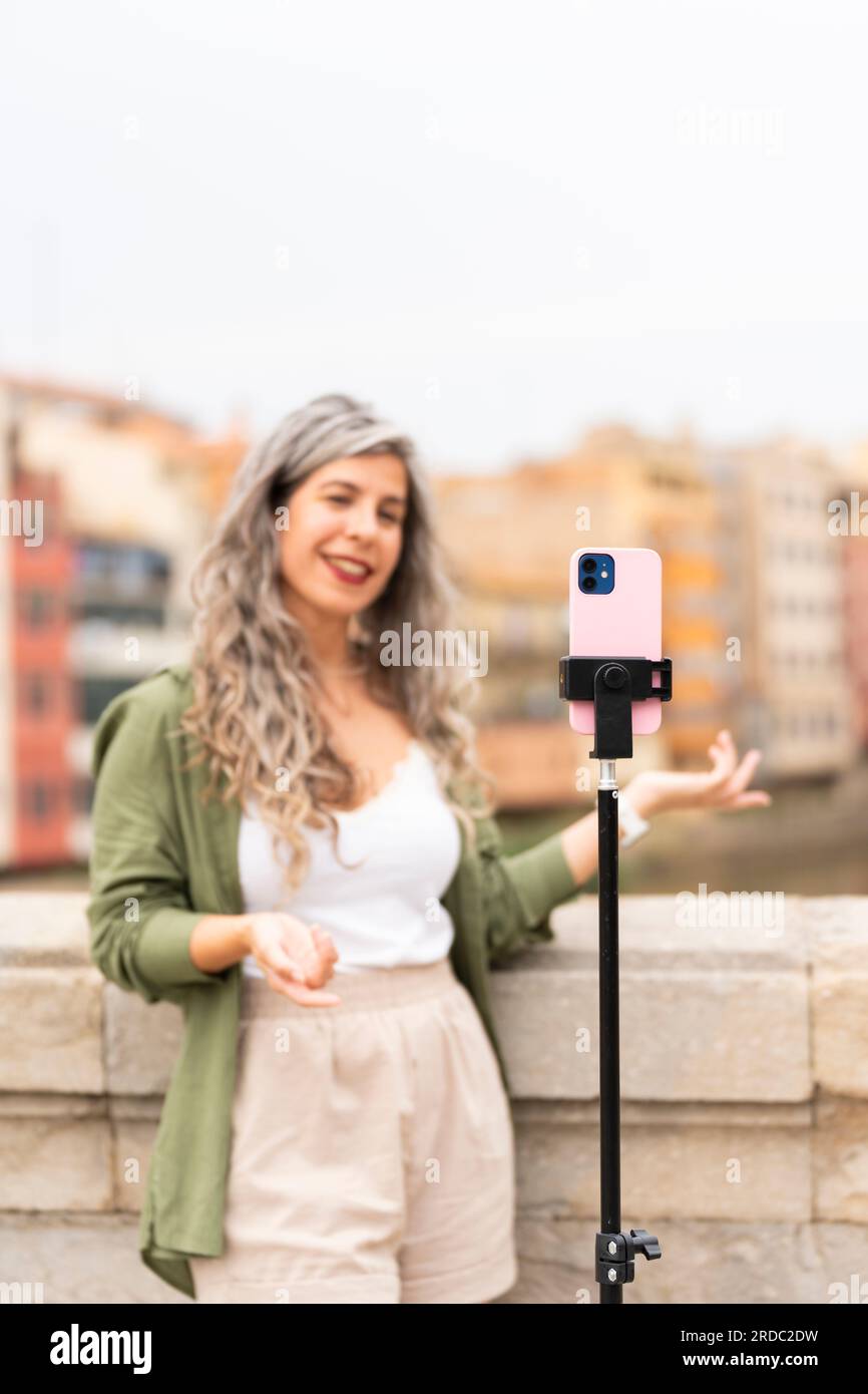 Influencer woman records herself talking about the city where she is located Stock Photo