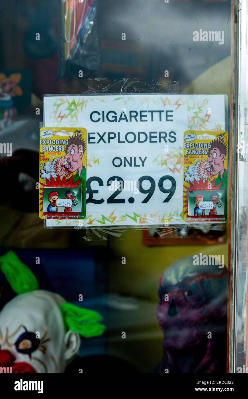 Cigarette exploders are advertised in a joke shop window, Newcastle, Co. Down, Northern Ireland. Stock Photo