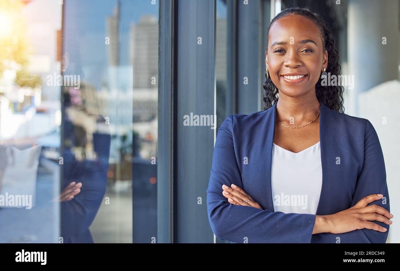 Portrait, window and arms crossed with a business black woman standing ...