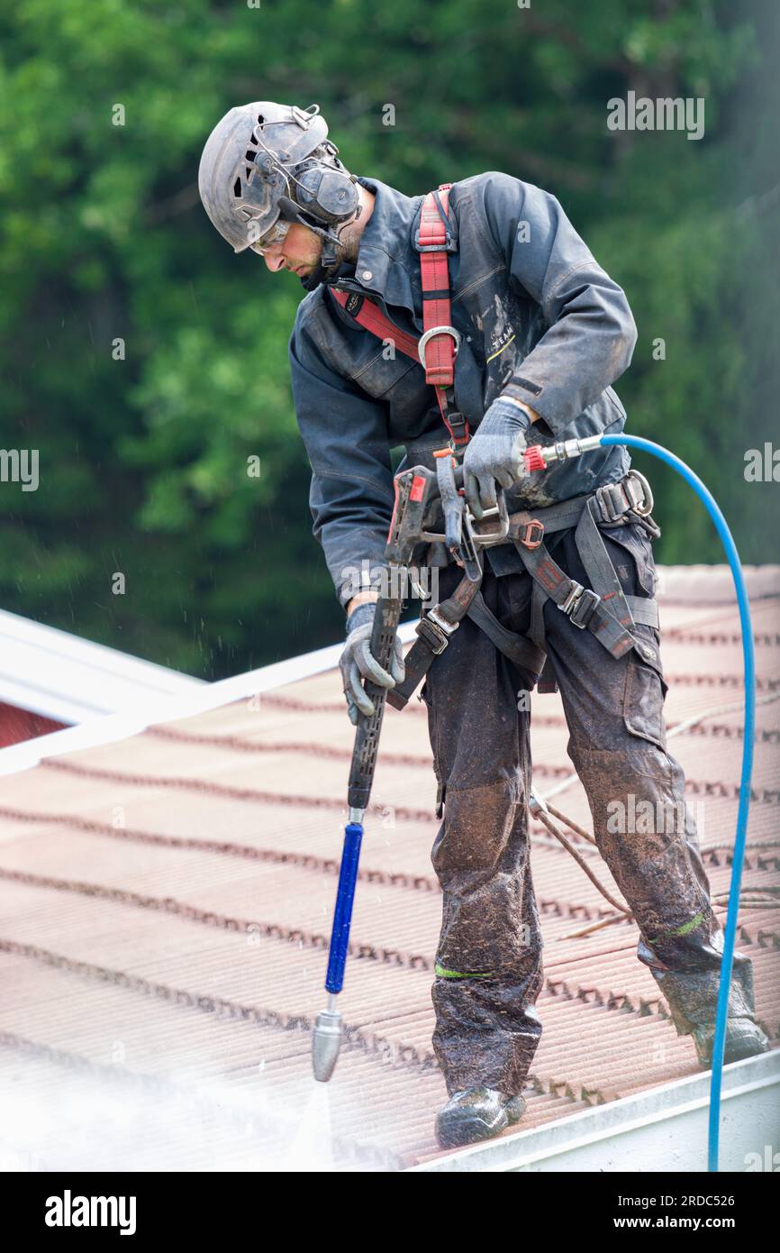 Professional tile roof cleaning with high pressure washer Stock Photo