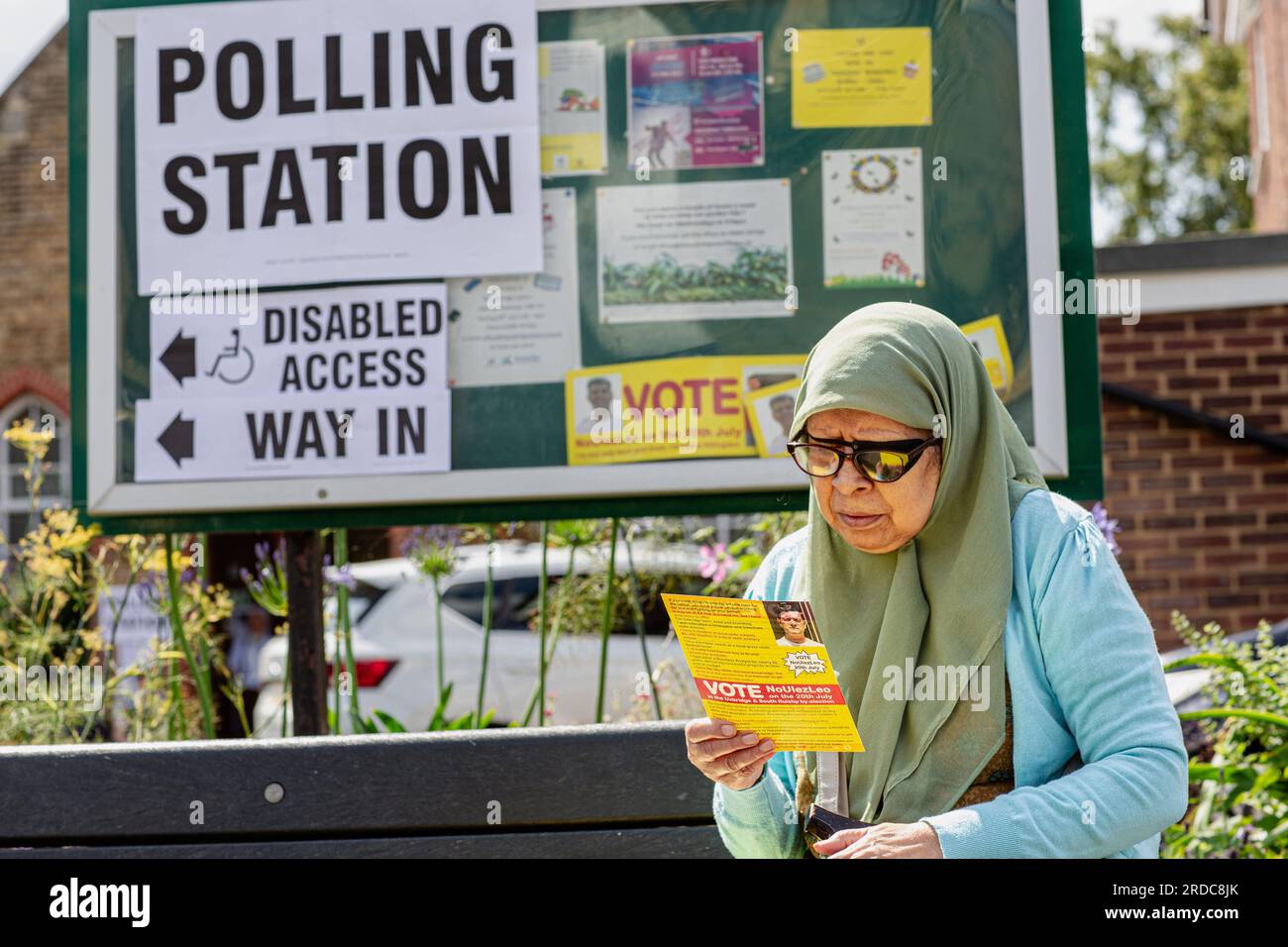 A voter reading  a flyer in front of polling station at the Uxbridge Community Center during a by-election in the northwest London constituency of Uxbridge and South Ruislip on July 20, 2023. Voters headed to the polls in three by-elections across England, with Prime Minister Rishi Sunak's ruling Conservatives braced for defeat in each as inflation-battered Britain's economic woes bite.Credit: Horst Friedrichs/Alamy Live Stock Photo