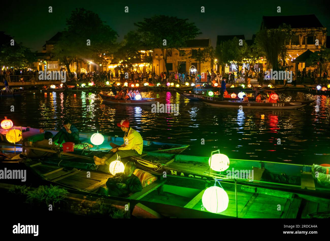 Vietnamese boatmen wait for passengers at night as other tourist boats
