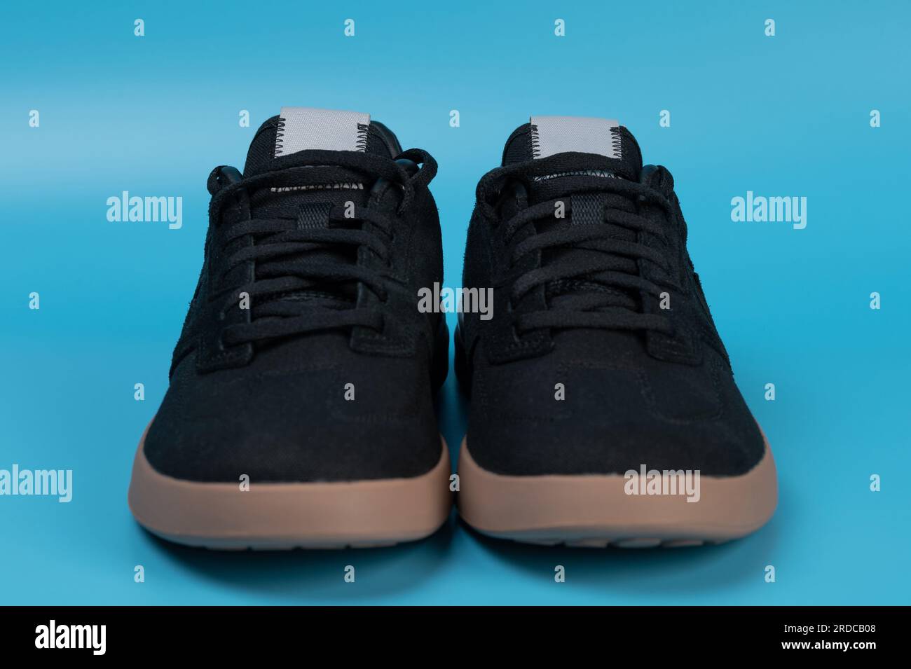 Front view of black casual shoes isolated on blue studio background Stock Photo