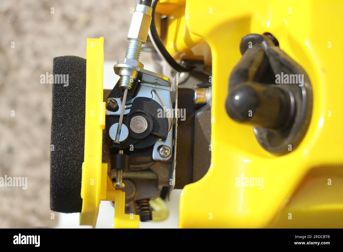 Mechanical components of a petrol brush cutter. Foam filter, starter or spark plug and choke lever in the carburetor of the thermal engine Stock Photo
