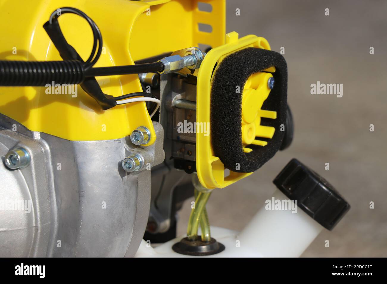 Gasoline pump hose for fuel supply in a brush trimmer. Parts of a gasoline powered bush trimmer with a view of carburetor and throttle cables Stock Photo