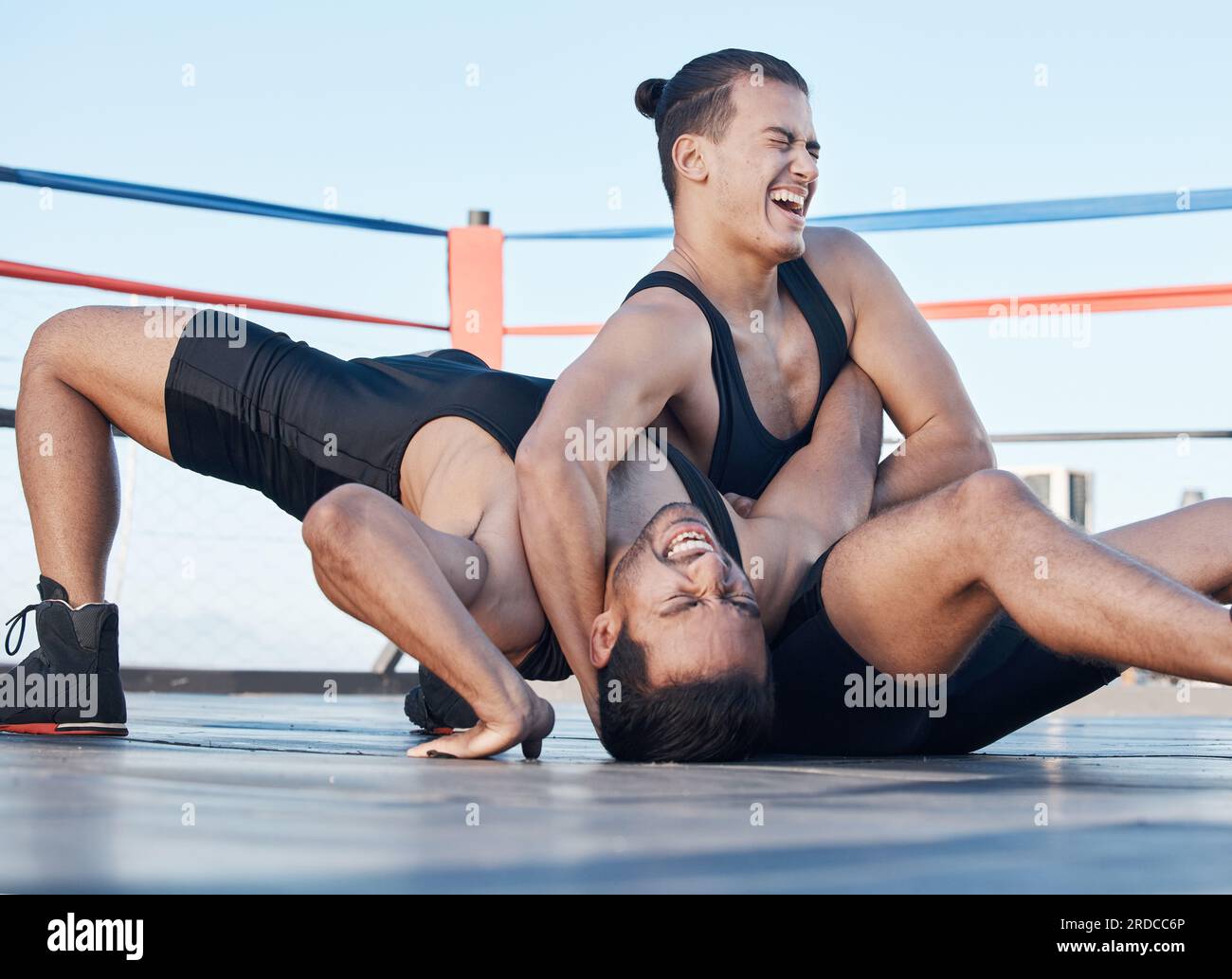 Men, wrestling and competition in a ring, mat or athlete winning in a tournament, match or training on floor of an arena. Fighting, match or Stock Photo
