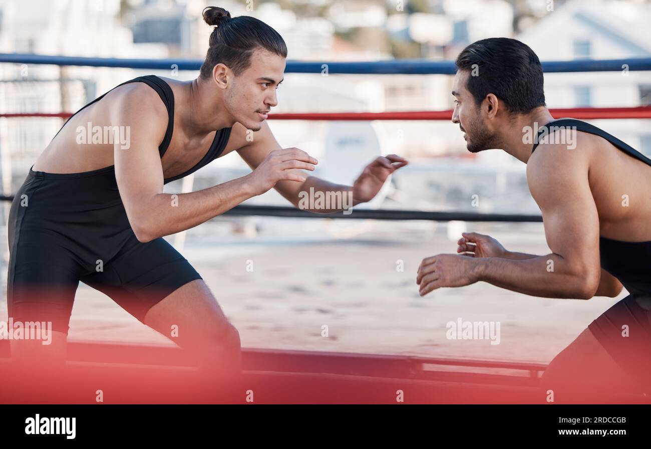 Men, wrestling and sport fight in ring with challenge, patient and focus for contest in metro cbd. Combat athlete, martial arts coach and thinking for Stock Photo
