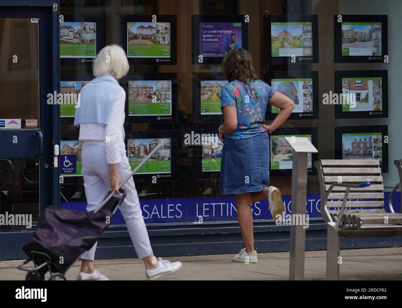 People looking at advertisements in an estate agents window in