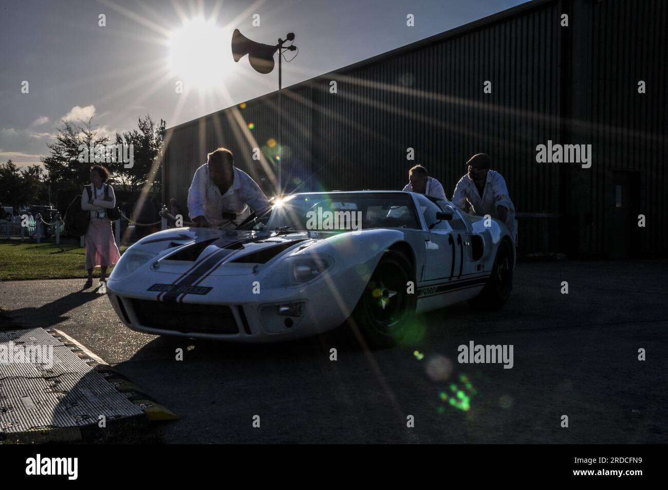 Mechanics pushing a classic Ford GT40 racing car out to race early in the morning at the Goodwood Revival 2013. Event preparation Stock Photo