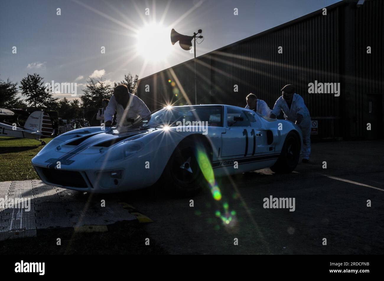 Mechanics pushing a classic Ford GT40 racing car out to race early in the morning at the Goodwood Revival 2013. Event preparation Stock Photo
