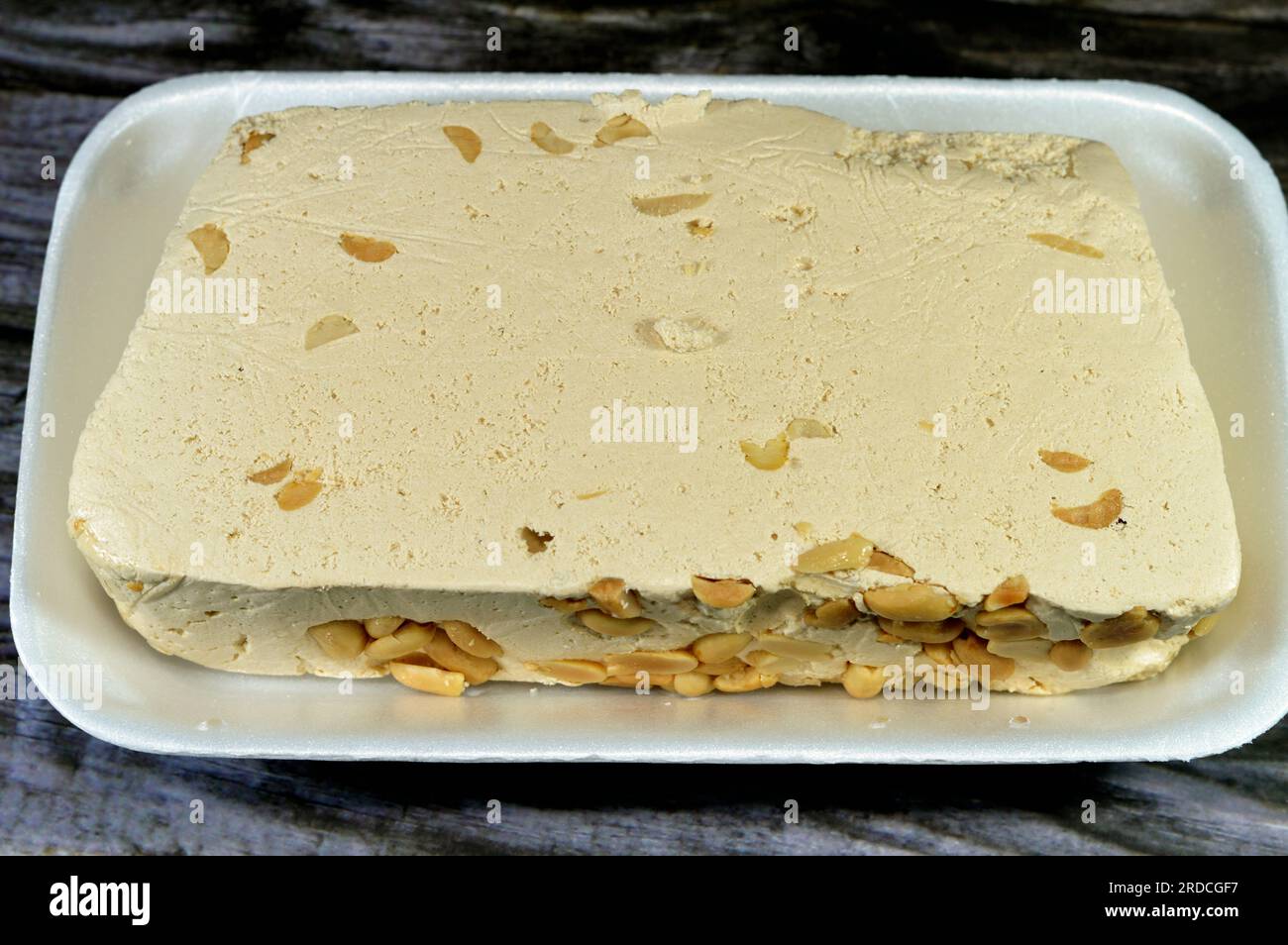 Traditional tahini halva with peanuts or Halawa Tahiniya, the primary ingredients in this confection are sesame butter or paste (tahini), and sugar, g Stock Photo