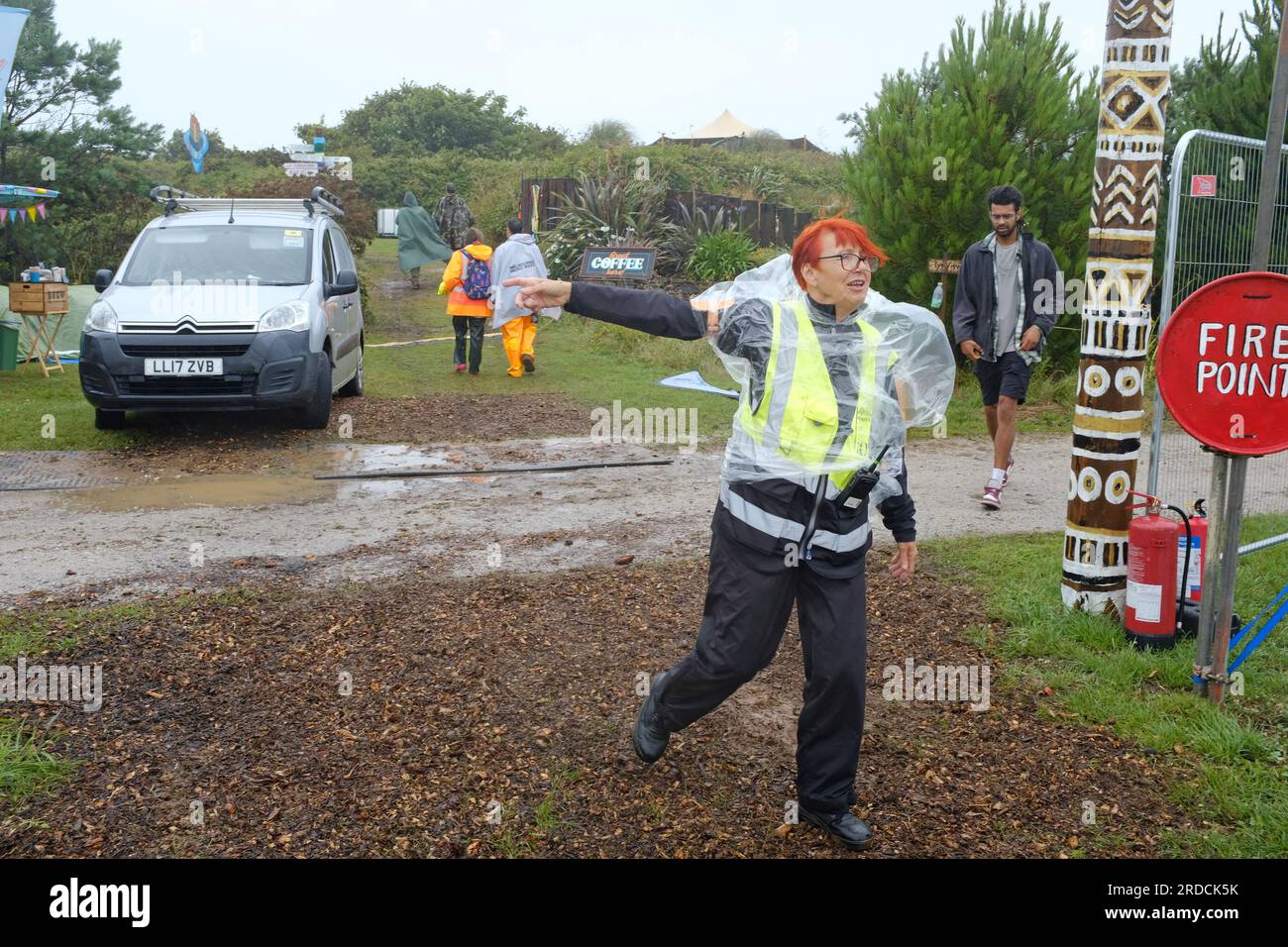 A festival worker directing traffic in bad weather. Stock Photo