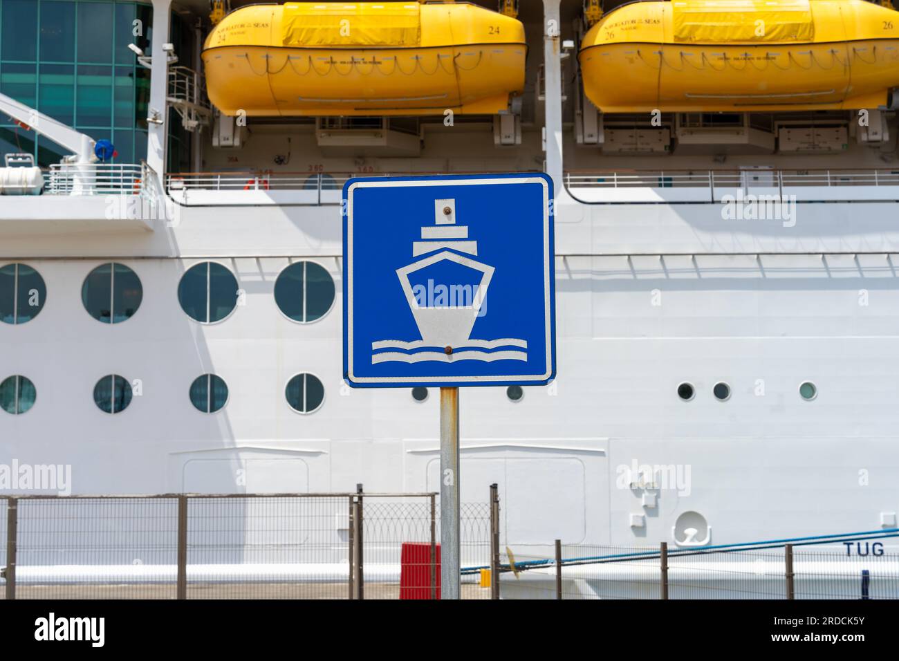 Ensenada, BC, Mexico – June 4, 2023: A ship dock metal sign posted at the Port of Ensenada with Royal Caribbean’s Navigator of the Seas cruise ship in Stock Photo