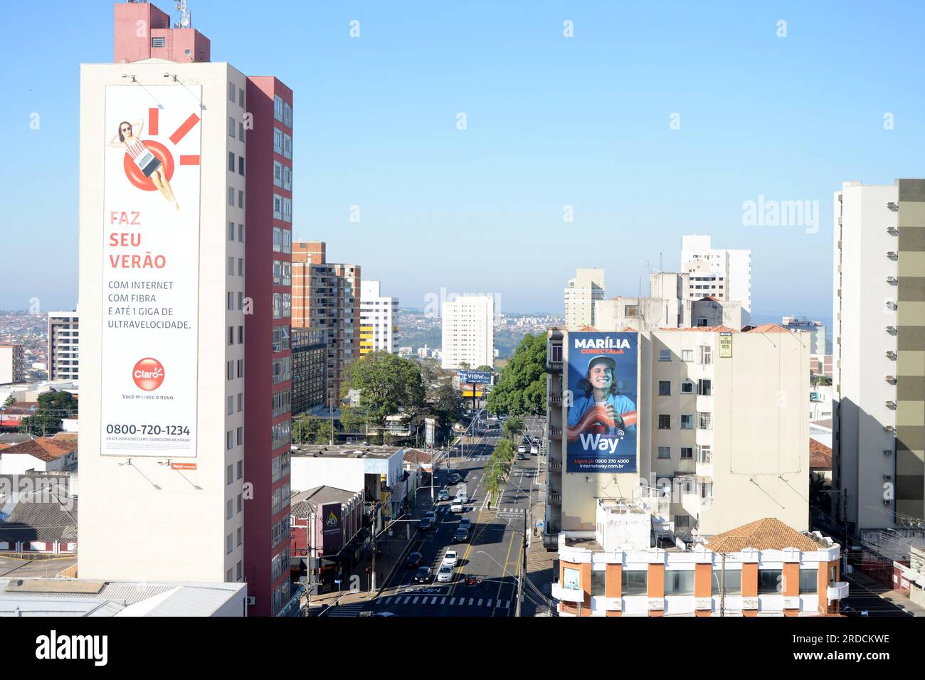 Avenue in the interior of São Paulo with advertising in an apartment building with cars and people on the streets. Panoramic Stock Photo