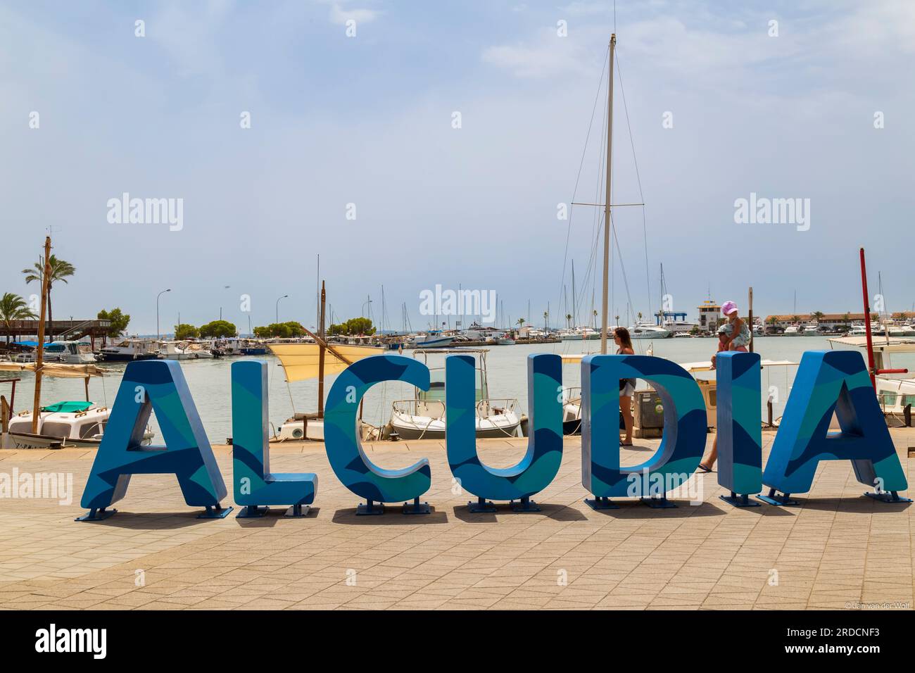 Sign with large blue letters reading Alcudia, on the promenade of the resort of Alcúdia, in the north of the Mediterranean island of Majorca in Spain. Stock Photo