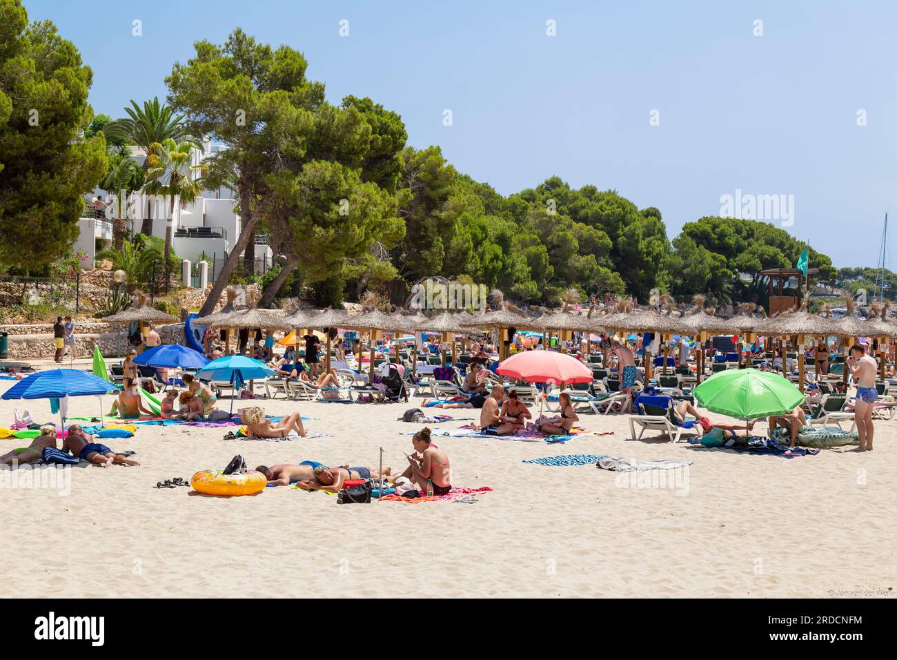 People enjoy the beautiful beach of the resort of Cala d'Or on the