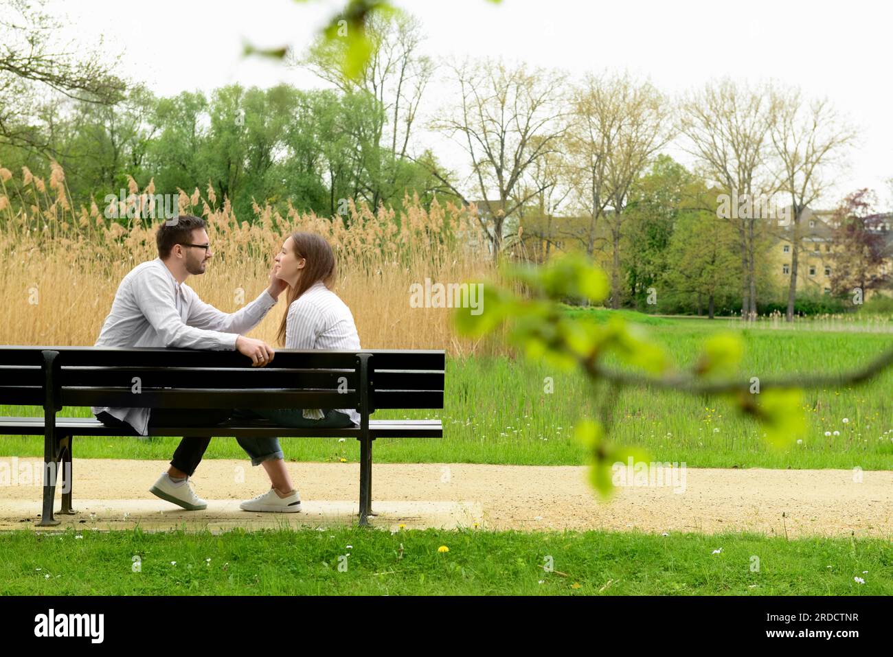 Beautiful loving couple sitting on bench in park Stock Photo - Alamy