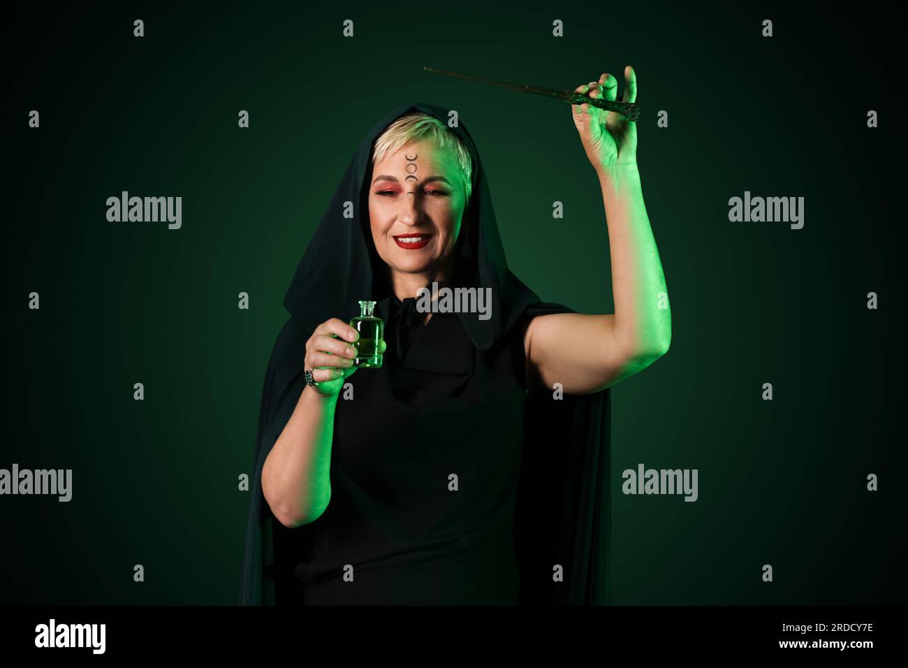 Mature witch with poison and magic wand on dark background Stock Photo ...