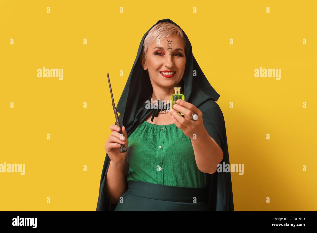 Mature witch with magic wand and poison on yellow background Stock ...