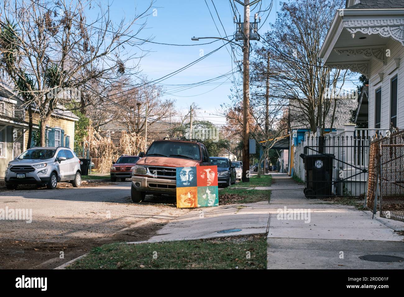 New Orleans, LA, USA - December 9, 2022: Cityscape of Uptown Neighborhood and abandoned Beatles painting on the curb with parked cars Stock Photo