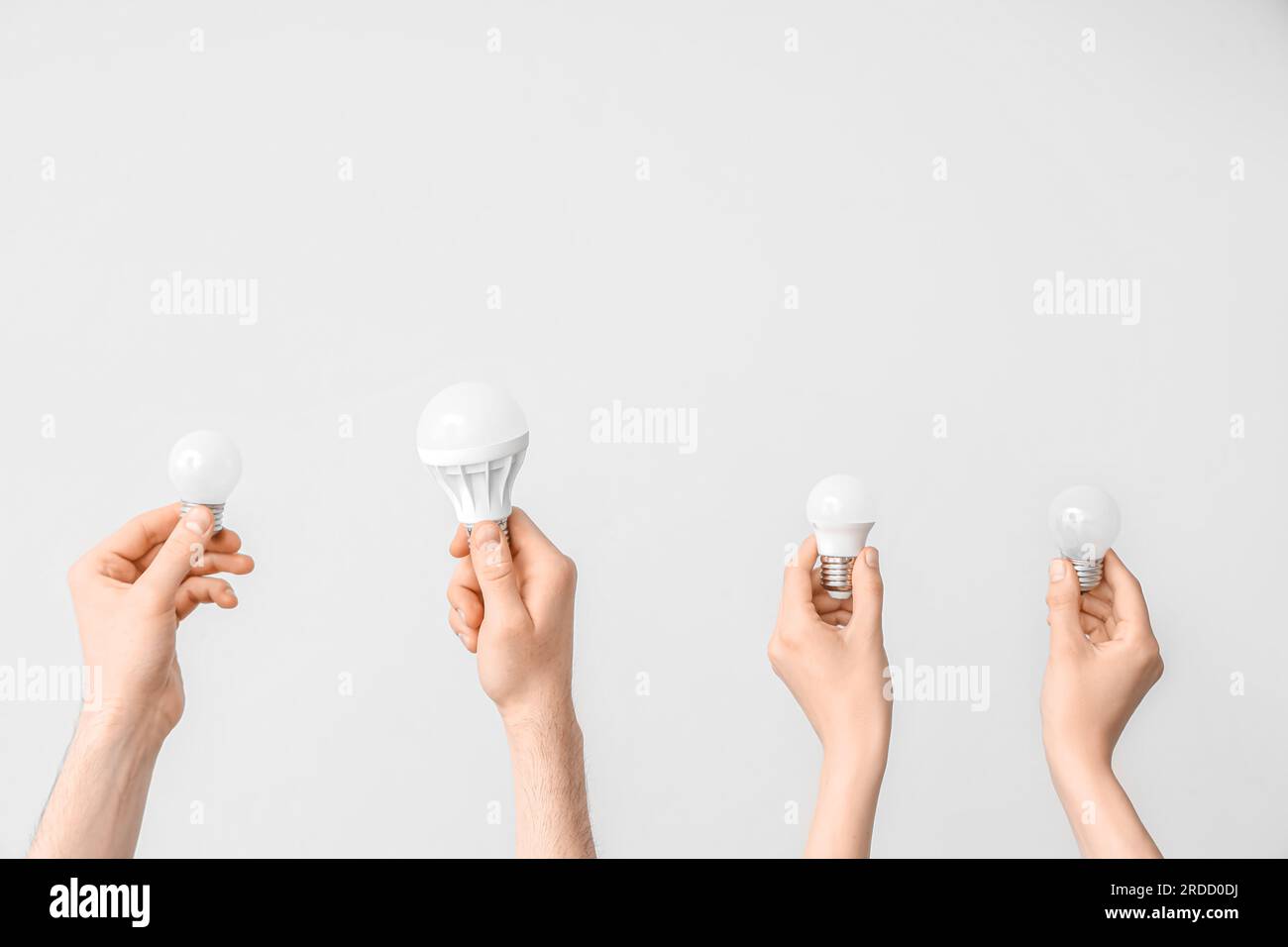 Electrician hands with light bulbs on grey background Stock Photo
