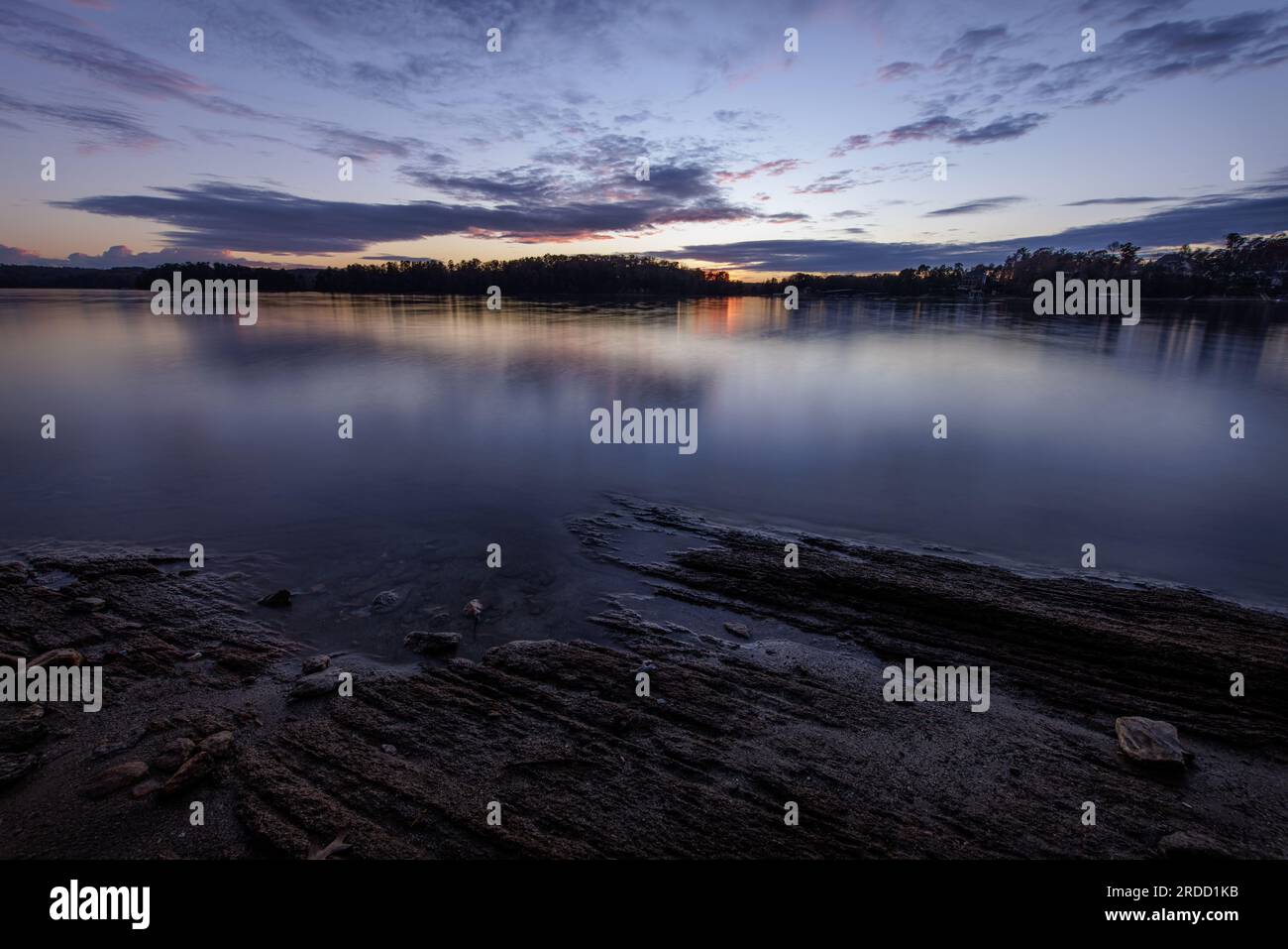Warm colors fade to the blue hour as the sun falls below the horizon on Lake Lanier. Stock Photo
