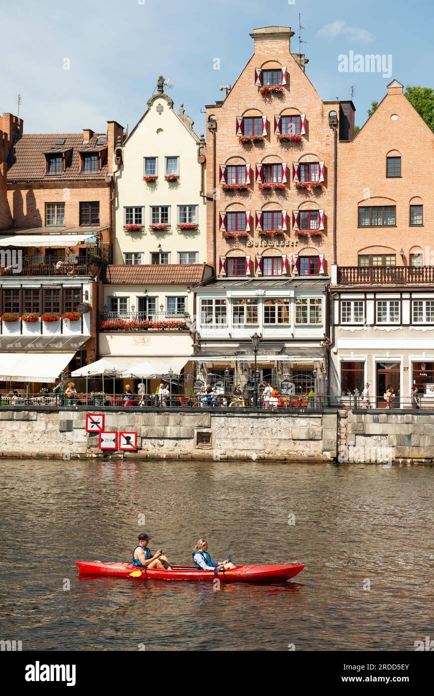 Tourists couple kayaking on Motlawa River by the Goldwasser Restaurant in the Gdansk Old Town of Gdansk, Poland Stock Photo