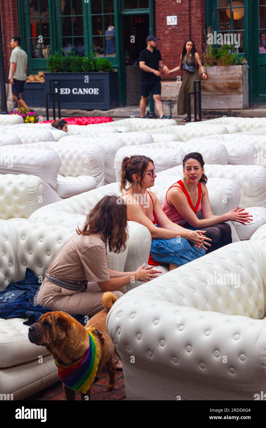 Three young women talking while seated on inflatable couches in the