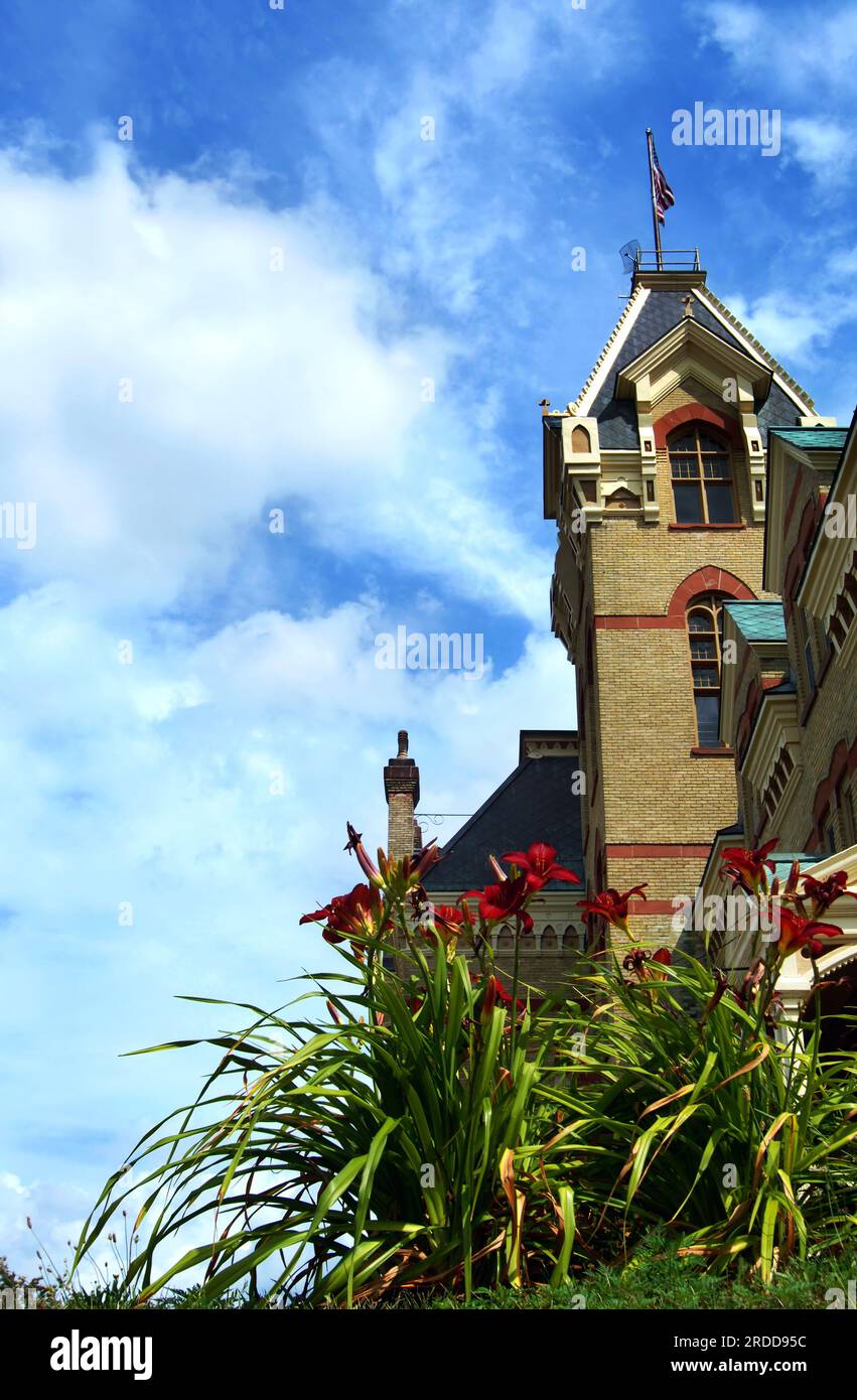 Victorian era, Houghton County Courthouse in Houghton, Michigan is designed with local red sandstone and Lake Superior copper for the roof.  Red lilli Stock Photo