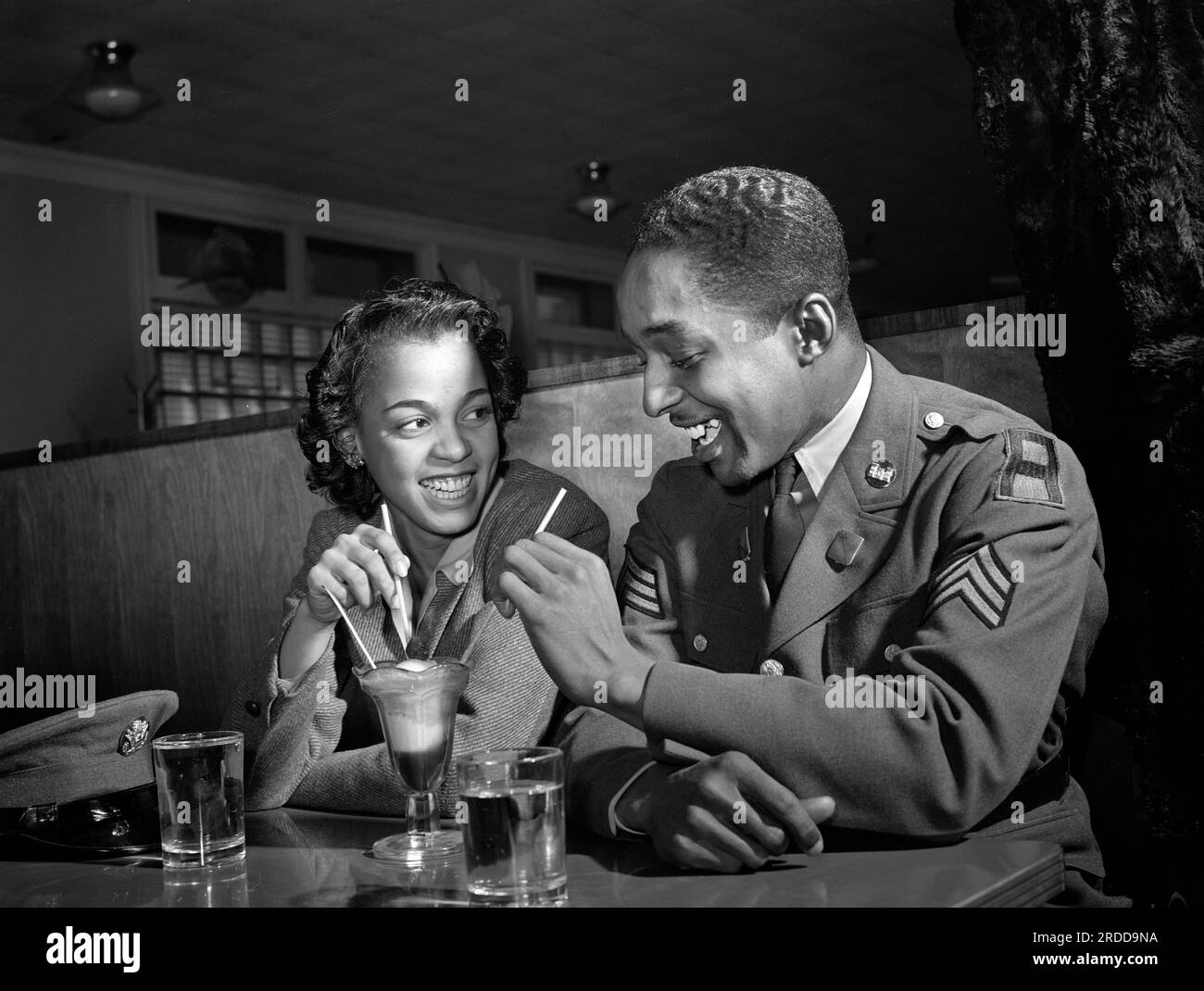 Sergeant Franklin Williams, home on leave from U.S. Army duty, with girlfriend Ellen Hardin, splitting a soda, Baltimore, Maryland, USA, Arthur Rothstein, U.S. Office of War Information. May 1942 Stock Photo