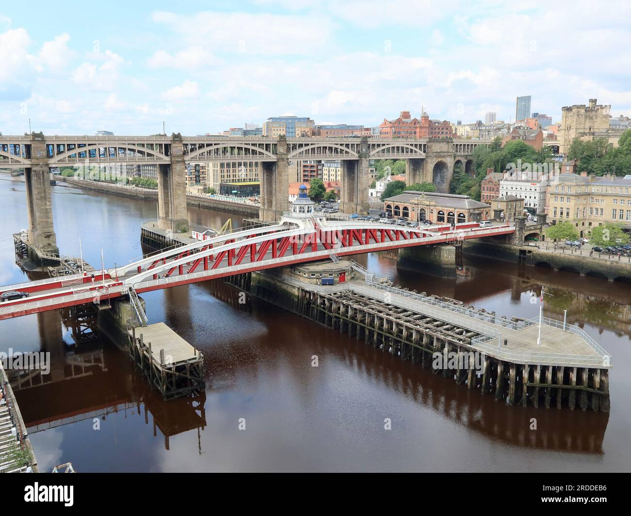 Newcastle, UK - 20 July 2023 : The red swing bridge over the river Tyne.  High level road and rail bridge in the background. Stock Photo