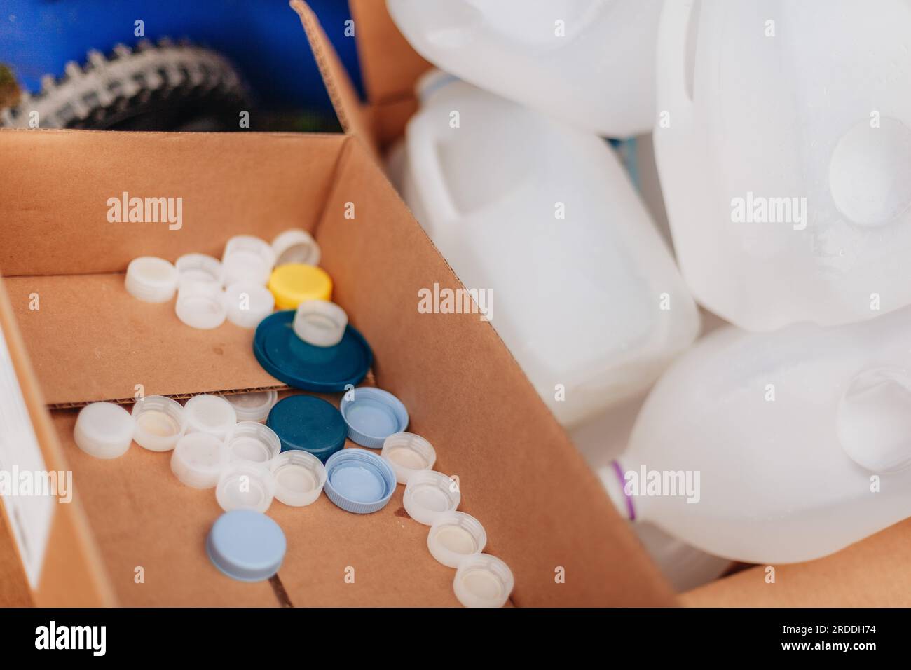Recycling and environmentally friendly, bottle caps in card board box among plastic bottles