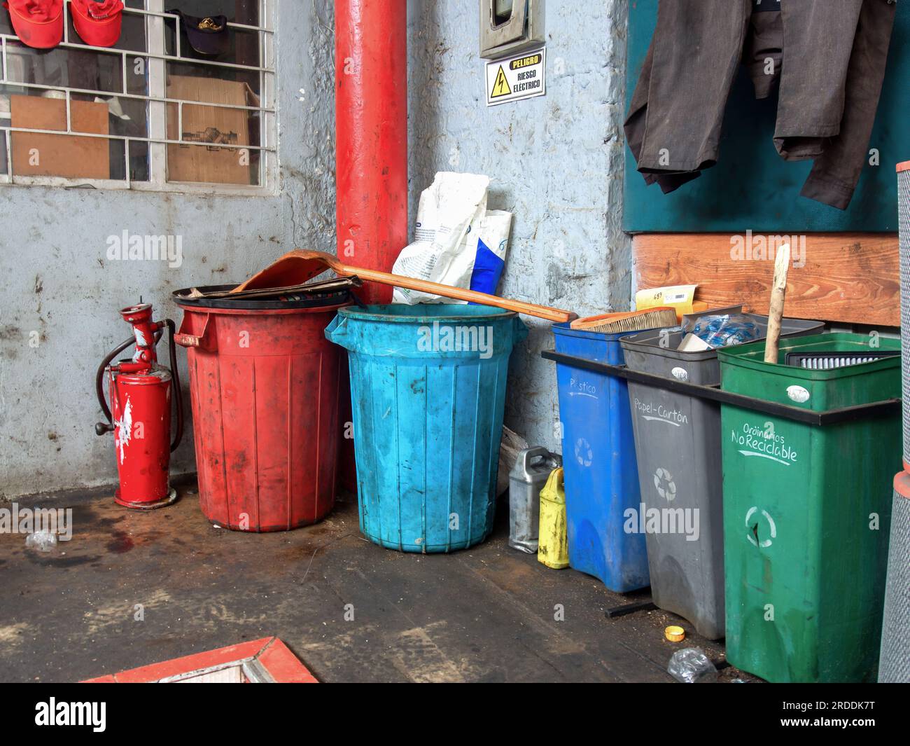 A messy trash corner in a car with three plastic bins labeled
