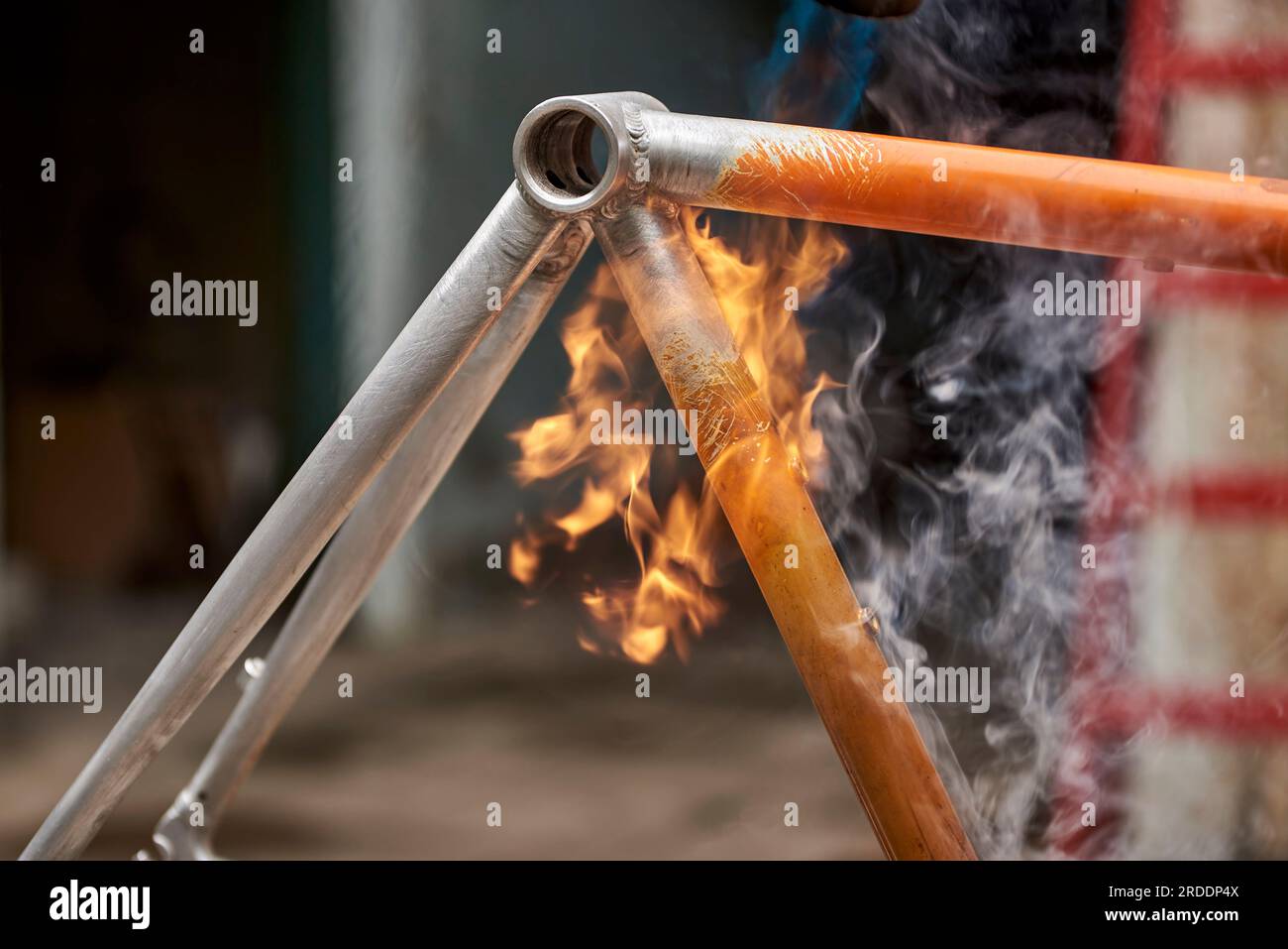 Manual bicycle renovation work, paint removal process using a torch