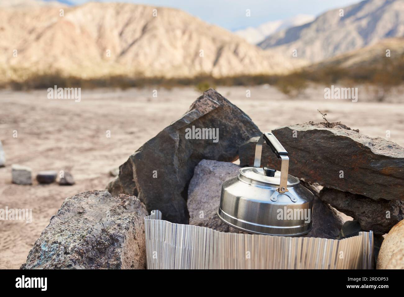 Heating water in a kettle placed in a heater sheltered from the wind in a camp in the mountains. Composition without people, with copy space. Stock Photo