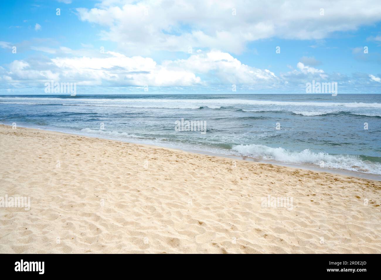 Sandy beach with the blue ocean and blue sky background Stock Photo - Alamy