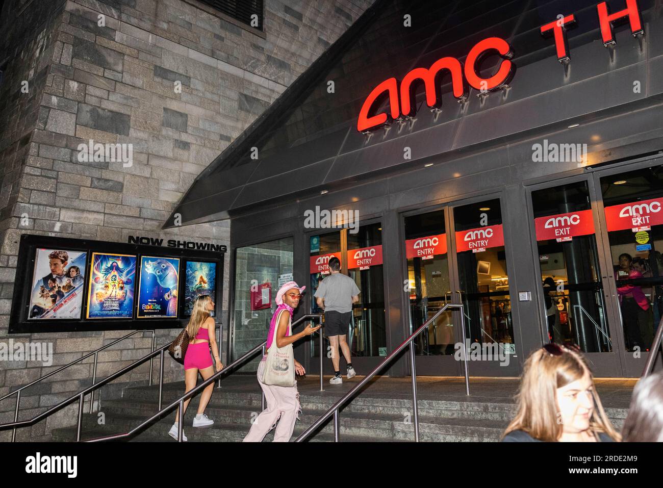 Washington DC, July 20, 2023. People dressed in pink enter AMC Theaters ahead of a showing of 'Barbie' during its debut at AMC Georgetown in Washington DC on July 20, 2023. The movie, released the same day as 'Oppenheimer' will be the first major motion pictures released during the actor and writers strikes that have suspended most Hollywood productions, including promotional materials for the two movies. Stock Photo