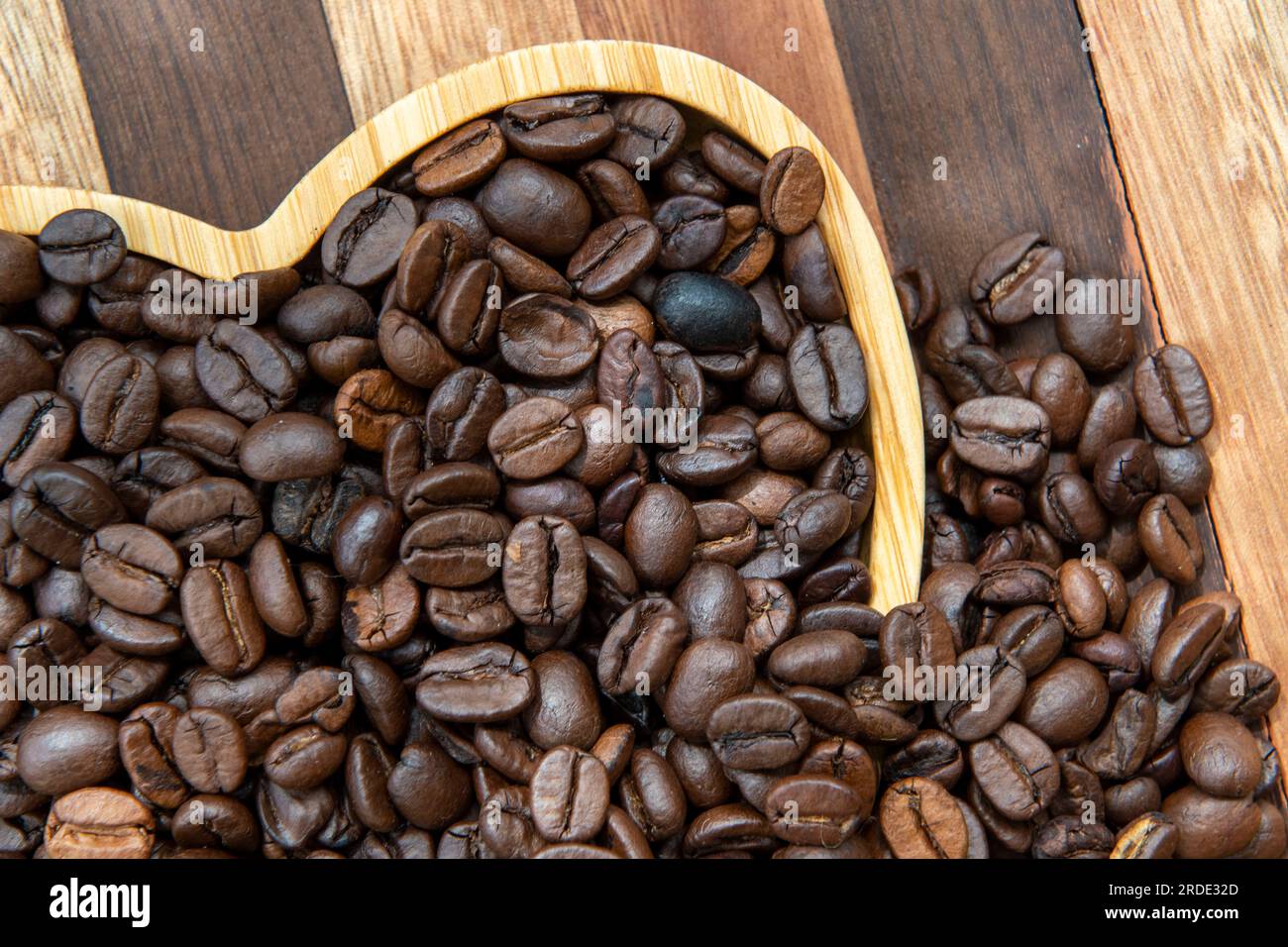 coffee beans in heartshaped tray and falling out, representing love of