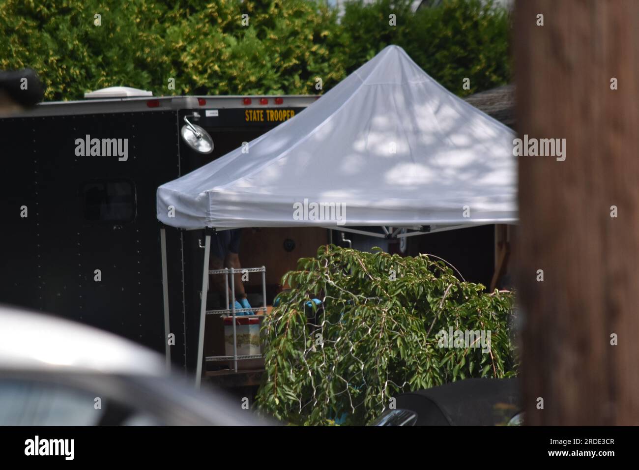 Authorities take out boxes of evidence from Rex Heuermann's house. Tents and several members of the crime lab of Suffolk County seen on the property. Investigators from the crime lab and the New York State Police Thursday, collect evidence from the storage unit of alleged Long Island New York Gilgo Beach serial killer Rex Heuermann. Crime scene investigators bring out evidence from the home and New York storage facility of Rex Heuermann in Long Island, New York on July 20, 2023. Rex Heuermann was arrested as a suspect in the Gilgo Beach serial killings. The massive police presence on First Ave Stock Photo